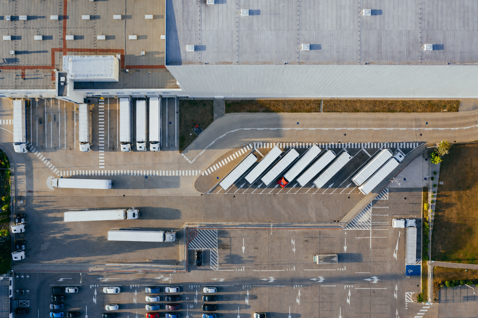 Aerial view of a logistics facility with trucks and parking spaces